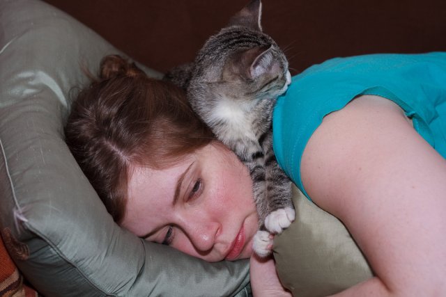 Julia Miller lying on the couch while Sasha lies on top of her.